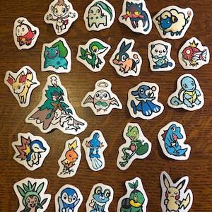 Puede incluir: Una colecci&oacute;n de veinticinco pegatinas troqueladas individuales que presentan coloridas ilustraciones de dibujos animados de varias criaturas ficticias. Cada pegatina tiene un borde blanco y representa un personaje &uacute;nico con rasgos, poses y colores distintos.