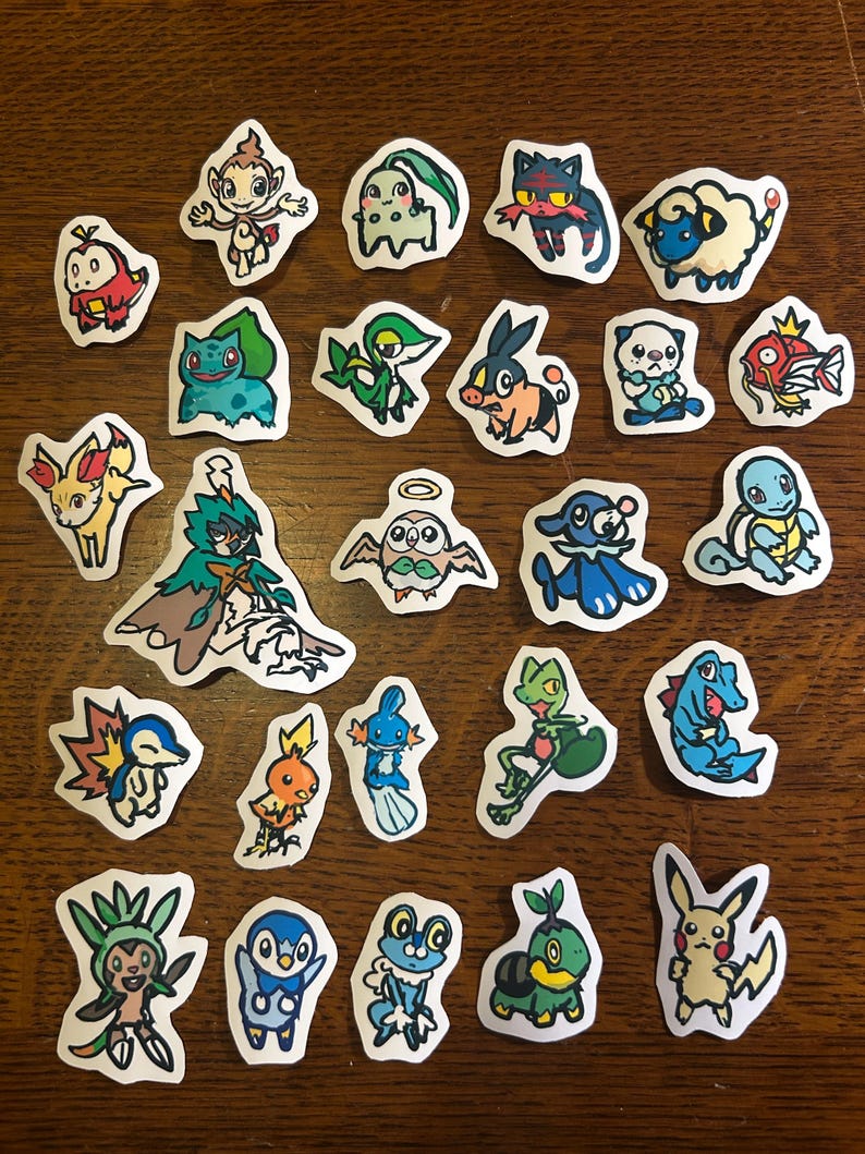 Puede incluir: Una colecci&oacute;n de veinticinco pegatinas troqueladas individuales que presentan coloridas ilustraciones de dibujos animados de varias criaturas ficticias. Cada pegatina tiene un borde blanco y representa un personaje &uacute;nico con rasgos, poses y colores distintos.