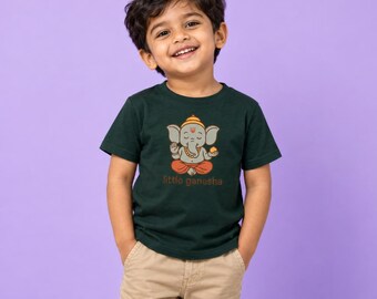 May include: A dark green short-sleeve t-shirt featuring a graphic of a cartoon Ganesha sitting in a lotus position with orange clothing and the text little ganesha printed in brown letters below the illustration.