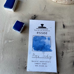 Op de afbeelding: Een monsterblad voor Maya Indigo natuurlijke aquarelverf. Het blad toont een blauwe aquarelwas met de tekst "Maya Indigo" en "Natural watercolors sample sheet www.esseee.eu" eronder.