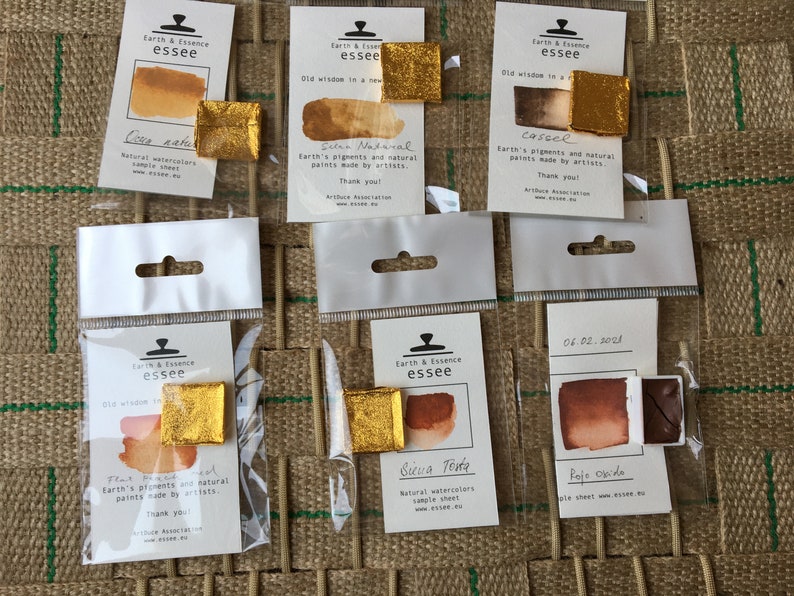 May include: Six small watercolour paint pans in individual plastic packaging. The pans are labelled with the brand name "Earth & Essence essee" and the names of the colours: "Cua natu", "Selen Natural", "Cassel", "Flat", "Birua Tota", and "Rojo Ocre".