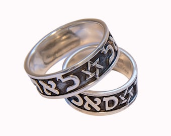 Op de afbeelding: Twee zilveren ringen met Hebreeuwse tekst en een Davidster. De ringen zijn in elkaar gehaakt.