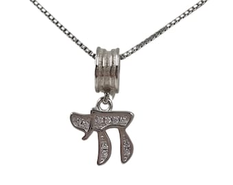 May include: A silver chain necklace with a silver pendant featuring the Hebrew letter Chai, adorned with clear cubic zirconia stones.
