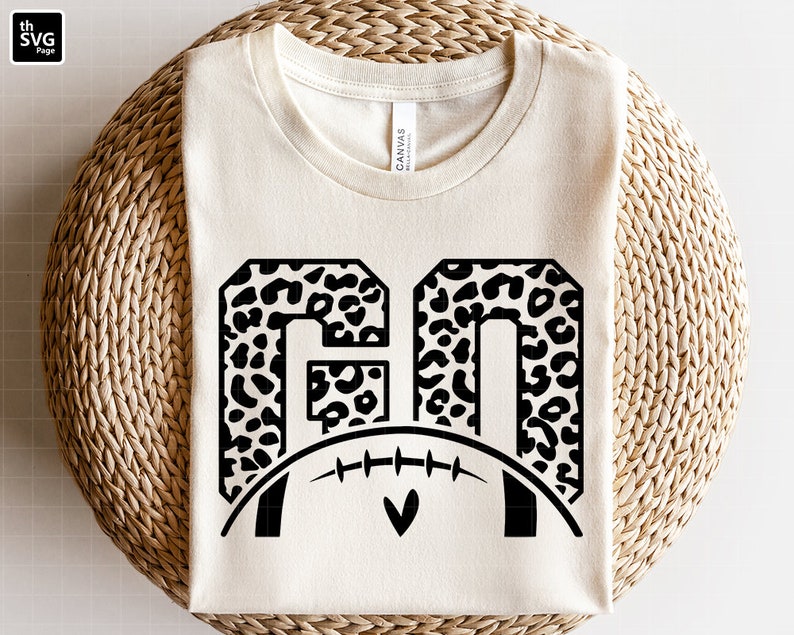 May include: A white t-shirt with a black and white leopard print design of the numbers "60" with a football underneath.