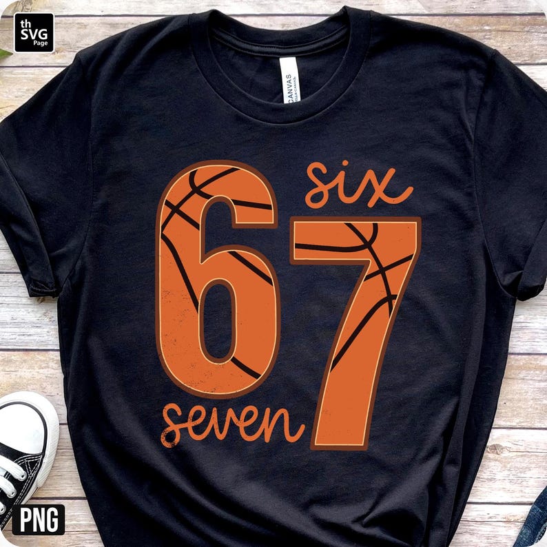 May include: Black t-shirt with a basketball-themed design. The design features the numbers "67" in orange, with a basketball texture, and the words "six" and "seven" in a script font.