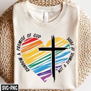 May include: A white t-shirt with a rainbow heart design and a black cross in the center. The text "RAINBOW A PROMISE OF GOD NOT A SYMBOL OF PRIDE" is printed around the heart.