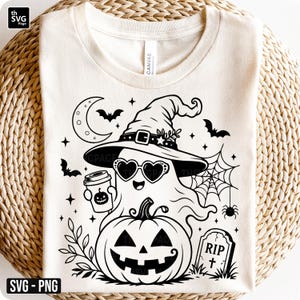 May include: A cream-coloured t-shirt featuring a black graphic of a ghost wearing a witch hat and heart-shaped sunglasses, holding a coffee cup with a jack-o'-lantern face. Below is a large pumpkin, a spider web, bats, a crescent moon, and a tombstone.