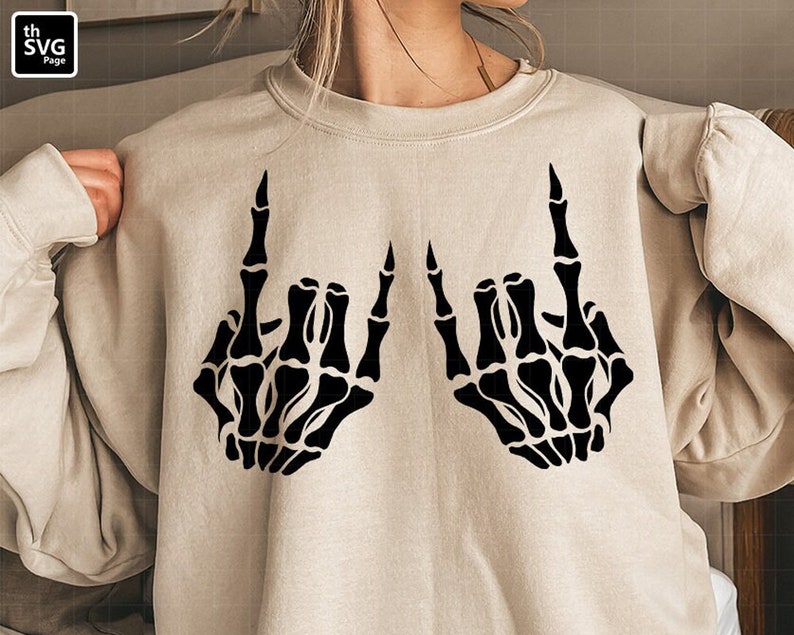 May include: A beige sweatshirt with a black skeleton hand design making the rock and roll hand gesture.