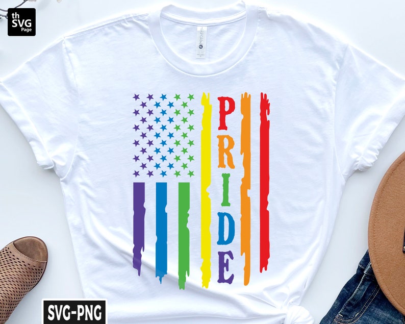 May include: White t-shirt with a rainbow-colored American flag design and the word "PRIDE" written vertically in the center.