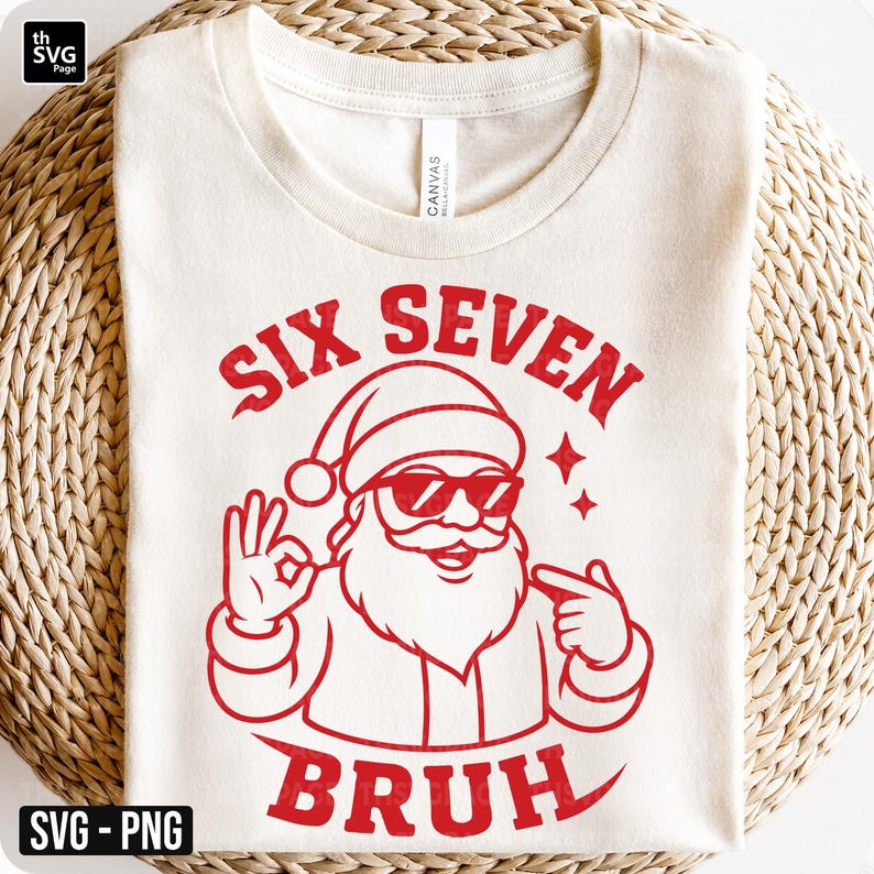 May include: Cream-colored t-shirt with a red graphic of Santa Claus wearing sunglasses and making an "okay" hand gesture. The text "SIX SEVEN BRUH" is above and below the Santa illustration. The shirt is on a woven surface.