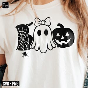May include: White t-shirt with a black Halloween-themed graphic. The design spells "Boo" with a spider web, a ghost with a bow, and a jack-o'-lantern. The shirt also has the text "SVG - PNG" at the bottom.