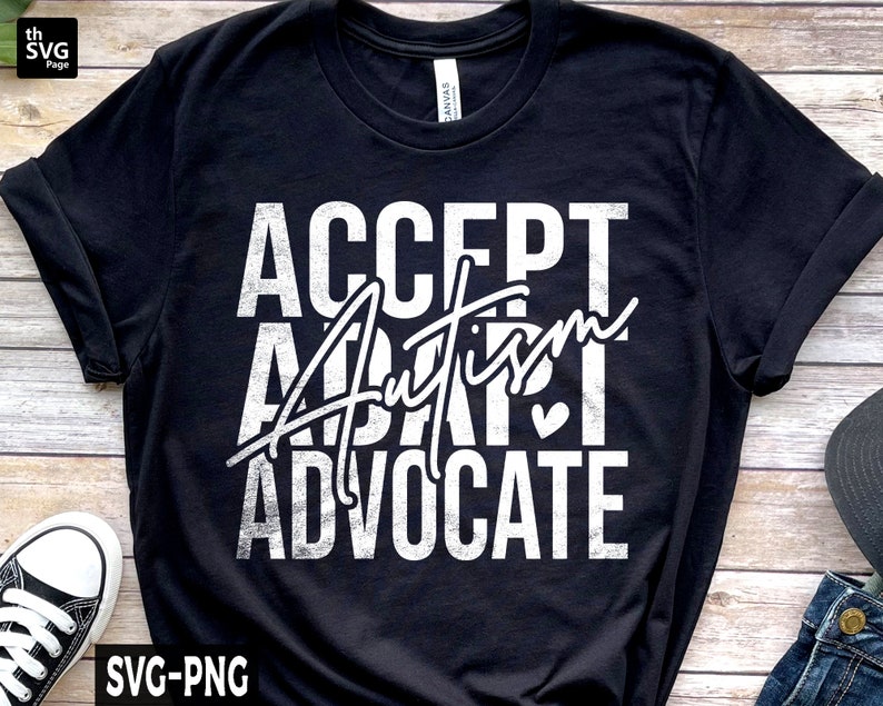 Op de afbeelding: Zwart T-shirt met witte tekst die "ACCEPT AUTISM ADVOCATE" luidt met een klein hartje.