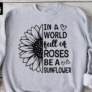 May include: Grey sweatshirt with a black sunflower graphic and the text "In a world full of roses be a sunflower".