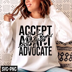 Op de afbeelding: Wit sweatshirt met zwarte tekst die "ACCEPT AUTISM ADVOCATE" luidt met een klein hartje.