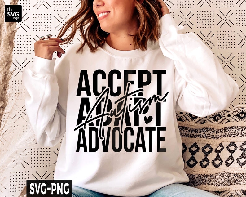 Op de afbeelding: Wit sweatshirt met zwarte tekst die "ACCEPT AUTISM ADVOCATE" luidt met een klein hartje.