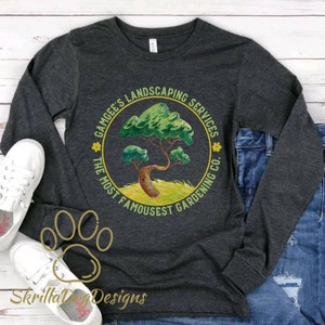 May include: A dark heather grey long-sleeve shirt with a circular design featuring a green bonsai tree, yellow flowers, and the text "Gamgee's Landscaping Services The Most Famousest Gardening Co."