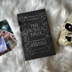 May include: A black book with a dark, ornate design and the title "The Vicious Dark" by USA Today bestselling author Candace Osmond.