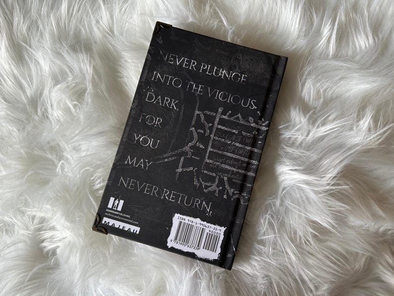 May include: Black hardcover book with the text "Never plunge into the vicious dark for you may never return." The book has a barcode and the word "Maleah" on the back cover.