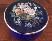 Cobalt blue porcelain lidded round box with flower design and gilded edges. Made in Japan.
