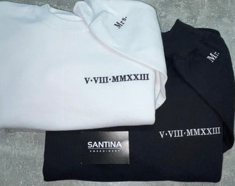 May include: Two sweatshirts, one white and one black, with the text "Mrs." and "Mr." embroidered on the sleeves. Both sweatshirts have the Roman numeral date "V.VIII.MMXXIII" embroidered on the front.