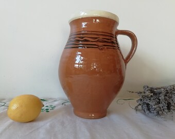 茶色の陶器の原始的な容器の水差し、アンティークの陶器のポット
