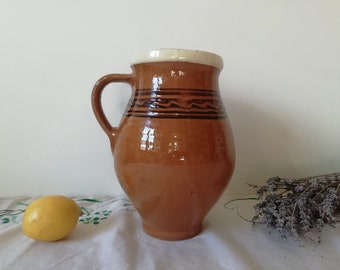 茶色の陶器の原始的な容器の水差し、アンティークの陶器のポット