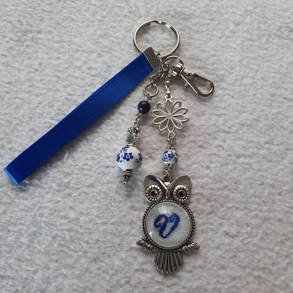 Porte clé ou bijou de sac à mains personnalisable , monogramme brodé dans chouette ou hibou, perle en porcelaine fleurs bleues.