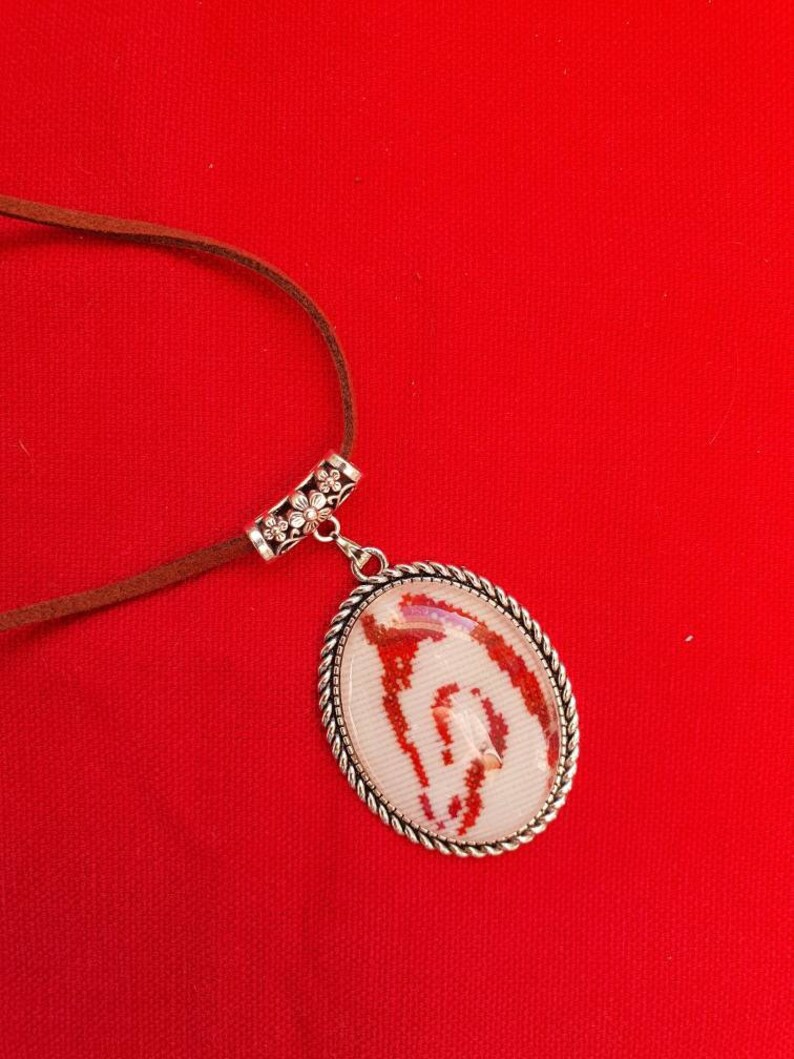 Horse pendant in fine embroidery under cabochon with adjustable leather lace.