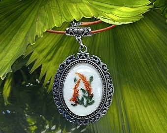 Pendentif  en argent tibétain motif fleuri en broderie fine sous cabochon.