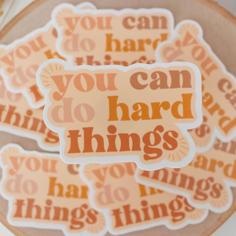 May include: A stack of stickers with the text "You can do hard things" in a retro font with orange, peach, and brown colors.