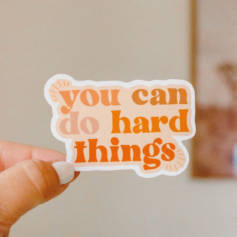 May include: A white sticker with orange and peach text that reads "you can do hard things".