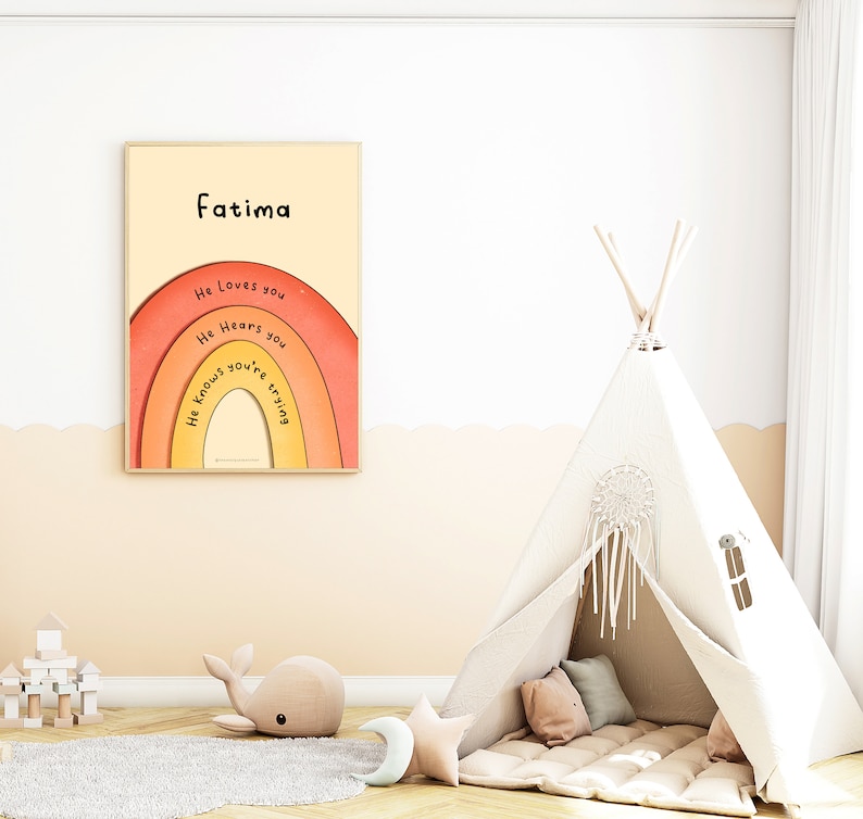 May include: A framed print with a rainbow design and the text "Fatima" at the top. The rainbow has the words "He loves you", "He hears you", and "He knows you're trying" written on it. The print is hanging on a white wall above a beige rug. A white teepee tent with a dreamcatcher hanging from the top is in the lower right corner of the image.