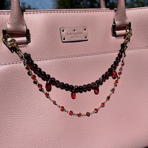 Deep crimson beads and gold chain details come together in this dark romantic purse charm, adding a bold statement to any handbag