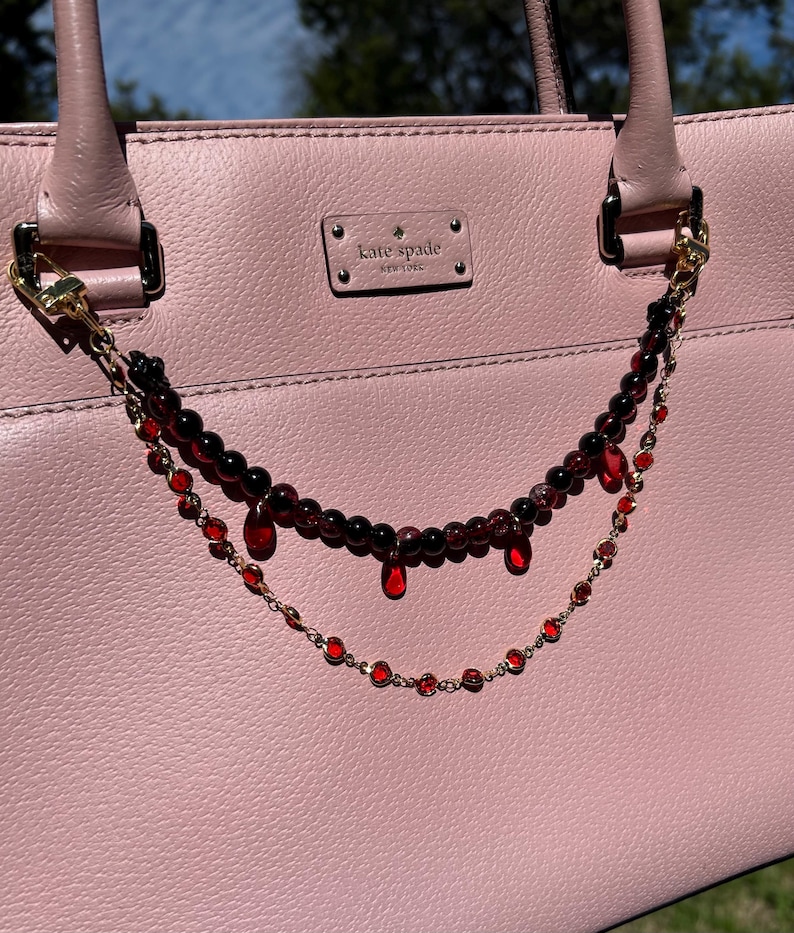 Deep crimson beads and gold chain details come together in this dark romantic purse charm, adding a bold statement to any handbag