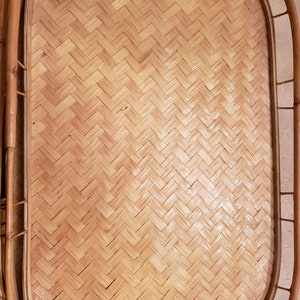 Può includere: Vassoio rettangolare in bambù con motivo a spina di pesce intrecciato. Il vassoio è di colore marrone chiaro e ha un bordo curvo. Il telaio è in bambù e ha una finitura naturale. Il vassoio è progettato per servire cibi e bevande.