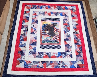 May include: A red, white, and blue quilt with a patriotic eagle design. The quilt features a central panel with an eagle and the words "America The Beautiful".