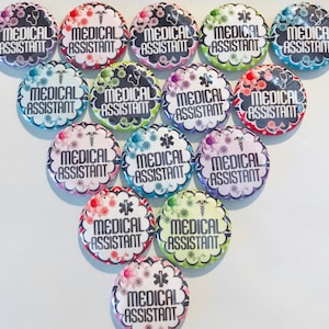 May include: A collection of 12 colorful round buttons with the text "Medical Assistant" printed on each button. The buttons have a variety of floral and star designs.