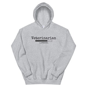 Pode incluir: Uma camisa de moletom cinza com capuz com o texto "Veterinarian" e uma barra de progresso que diz "LOADING..." embaixo.