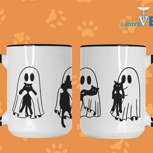 May include: Two white coffee mugs with black handles and black rims. Each mug features a black and white illustration of a ghost holding a black cat. The text "introVETed" is visible in the background.