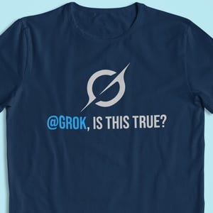 May include: A navy blue t-shirt featuring a white and grey graphic of a circle with a line through it. The text "@grok, IS THIS TRUE?" is printed below the graphic in blue and white.
