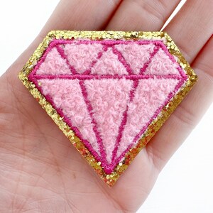 May include: Pink felt diamond shape with a gold glitter outline.