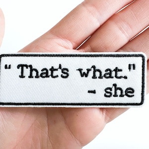 May include: White embroidered patch with black stitching. The patch reads "That's what" - she.