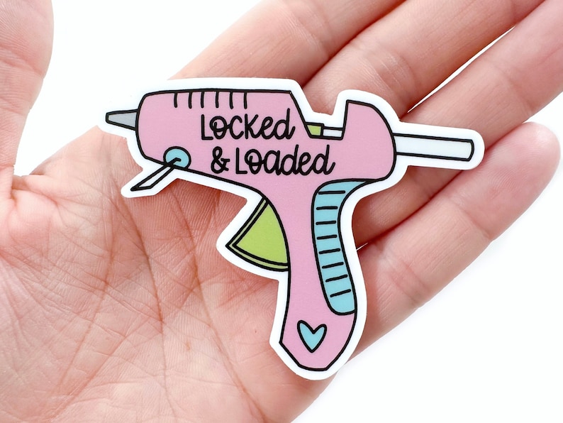 May include: A pink and white sticker of a glue gun with the text "Locked & Loaded".