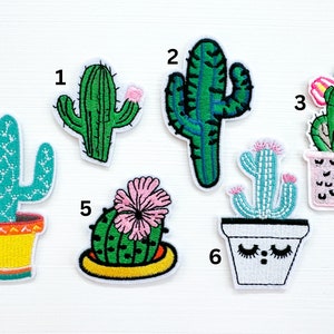 May include: Six embroidered cactus patches in various styles. The patches are green, blue, pink, and yellow. Some of the cacti are in pots with faces. The patches are numbered 1 through 6.