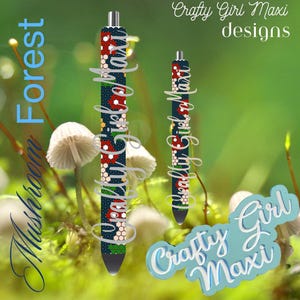 May include: Two blue and white pens with a floral pattern and the text "Crafty Girl Maxi" on them. The pens are in front of a green background with mushrooms.