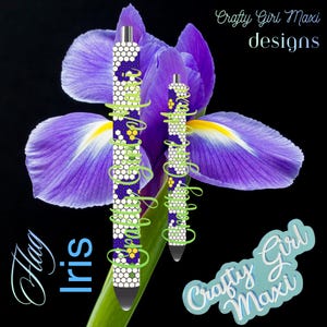 May include: Two pens with a honeycomb pattern in white, purple, and yellow, with green accents and the text "Crafty Girl Maxi designs". The pens are set against a purple iris flower with the words "Flag Iris".