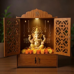 May include: A wooden temple with openwork doors and a carved Om symbol. Inside, a golden statue of Ganesha sits amidst marigold garlands. The temple is illuminated by a warm light, creating a serene atmosphere.