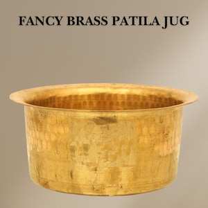 May include: A gold-coloured brass patila jug with a hammered finish. The jug is round and has a wide, flat base.
