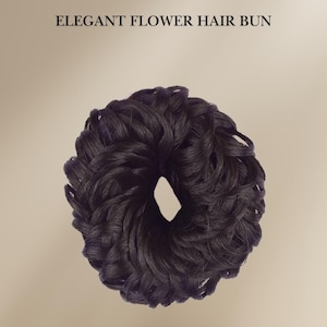 May include: A black hair bun maker, shaped like a donut, made of synthetic hair. It is a hair accessory used to create a bun hairstyle.