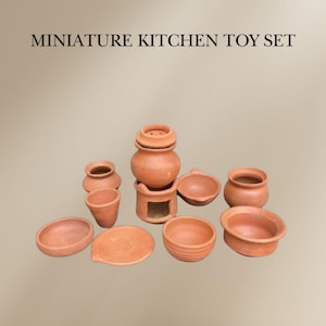 Pode incluir: Um conjunto de brincar de cozinha em miniatura de terracota com um fogão, panelas, frigideiras e pratos. O conjunto é feito de argila de terracota e é perfeito para brincar de faz de conta.